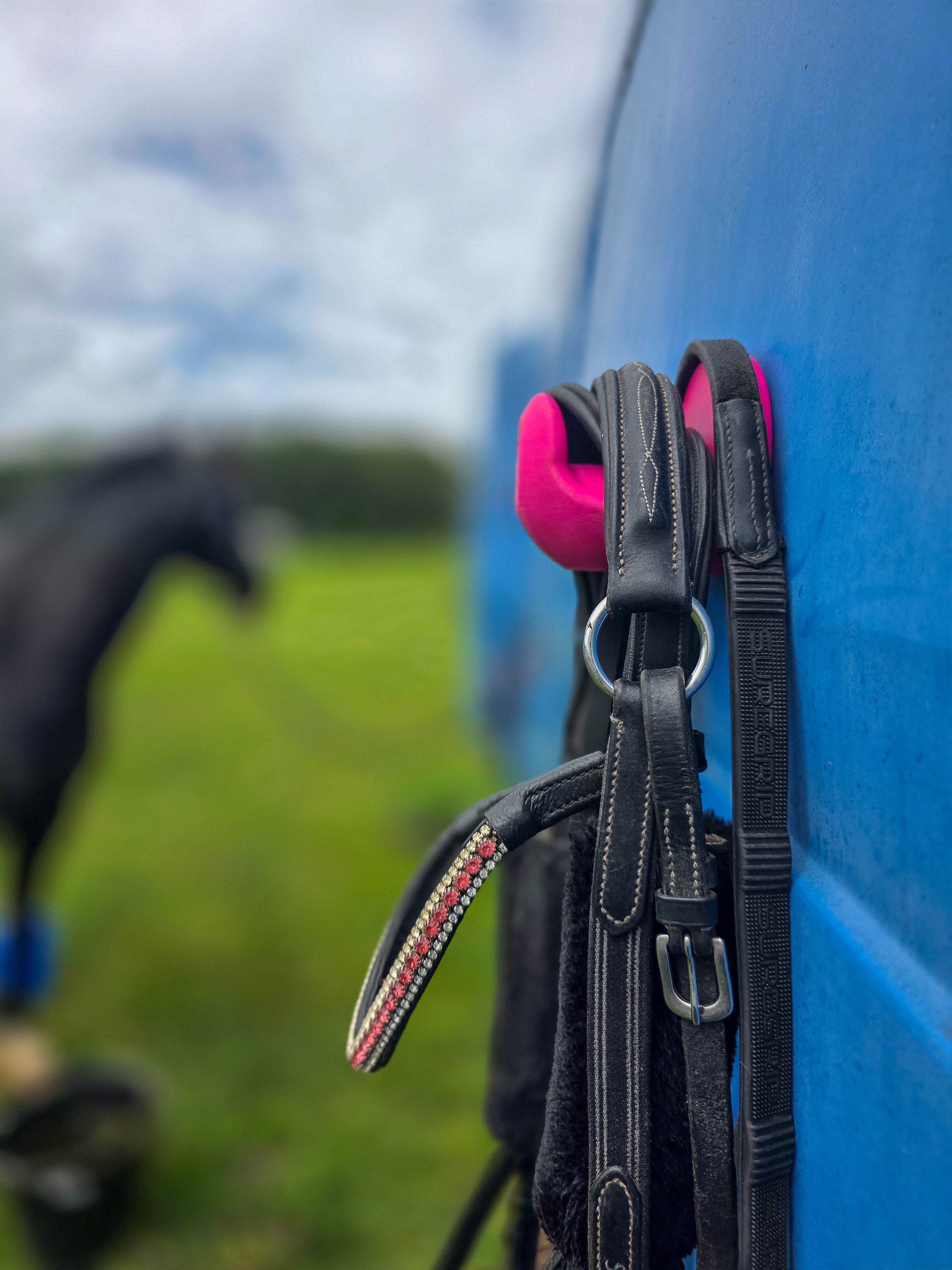 StablePin Plus dual magnetic hook mounted on a horsebox wall holding a bridle