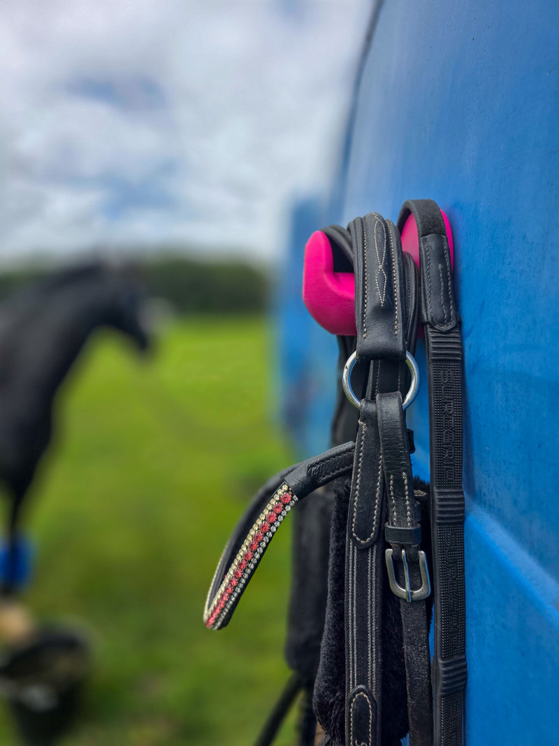 StablePin Plus dual magnetic hook mounted on a horsebox wall holding a bridle