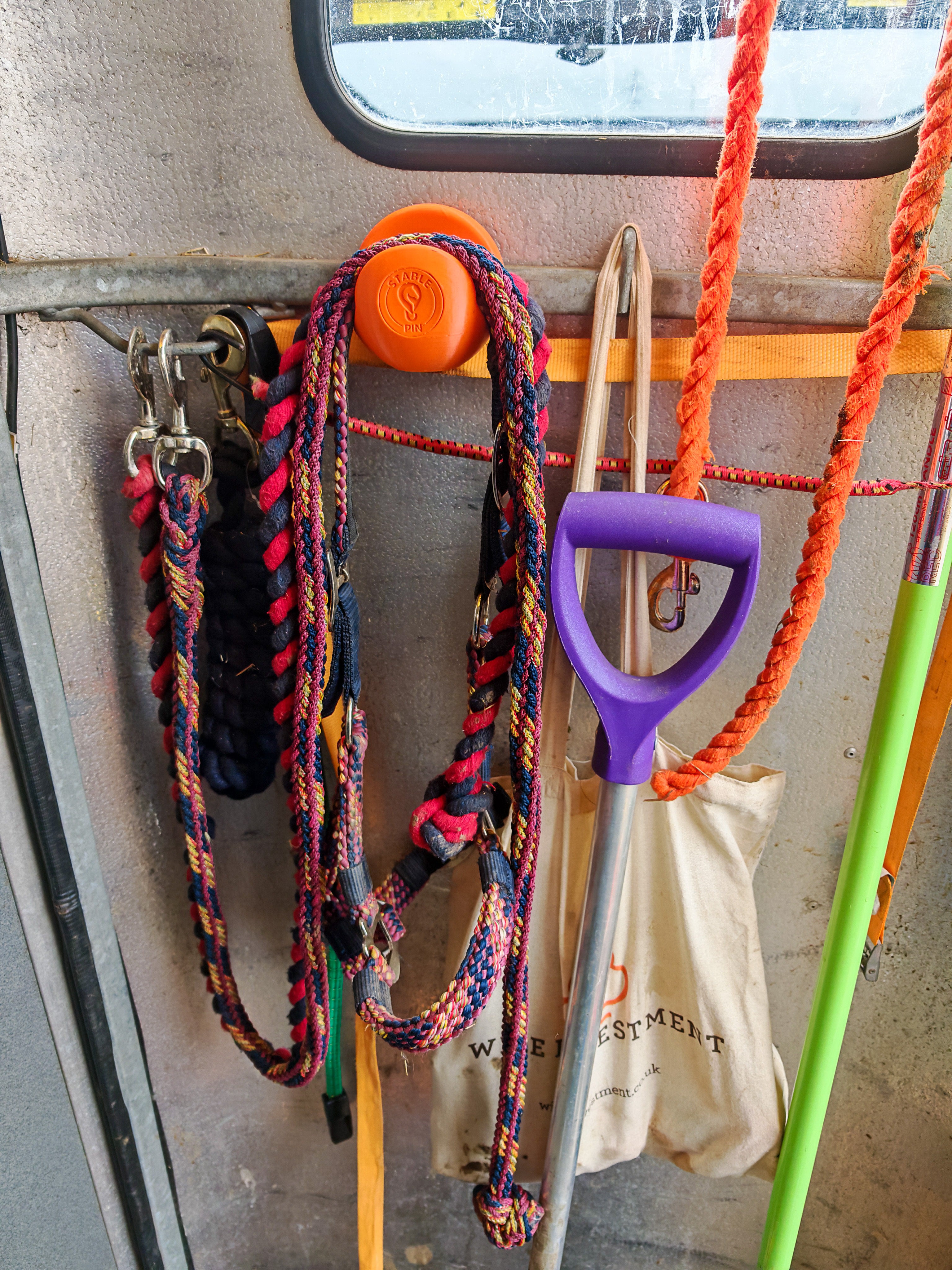 StablePin Core magnetic hook mounted inside a horsebox holding lead ropes and a yard brush